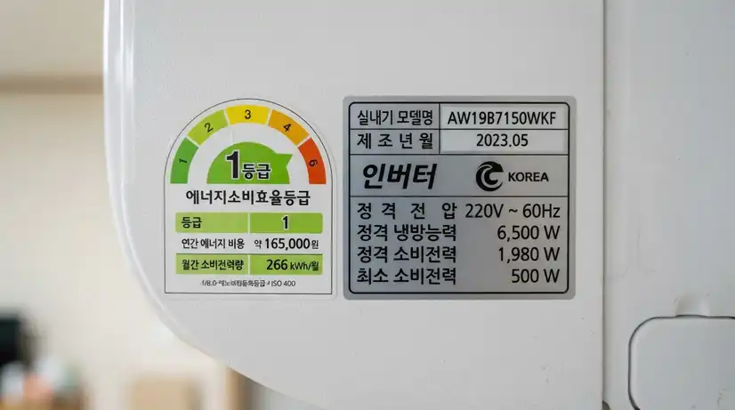 흰색 에어컨 측면에 붙은 인버터 정격 최소 소비전력 표시 스티커 매크로 접사